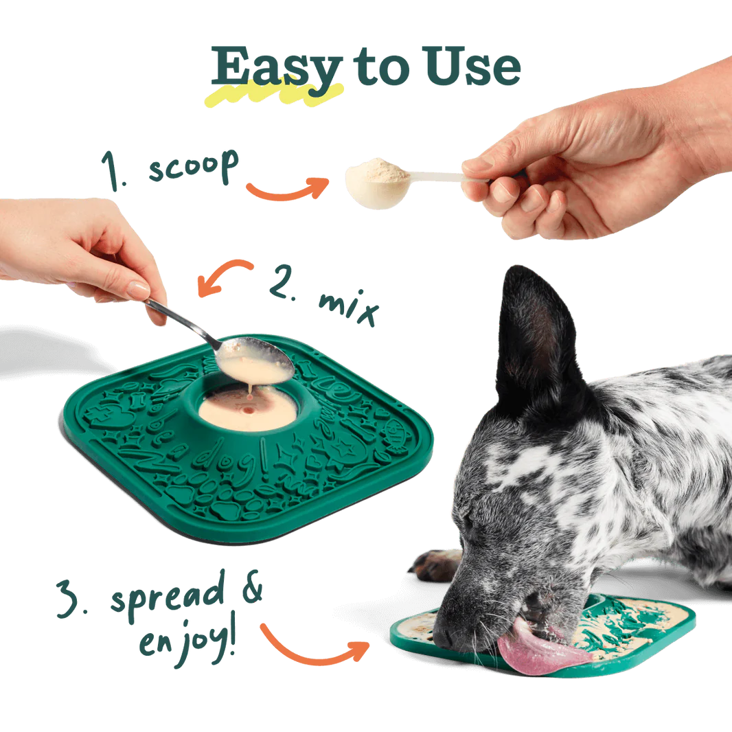 Dog eating from a green mat with instructions on how to use it, including scooping, mixing, and spreading.